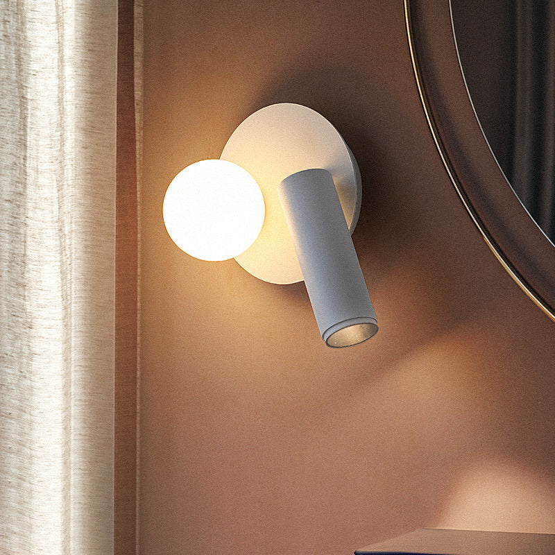 A modern wall lamp with a round base and an adjustable arm,