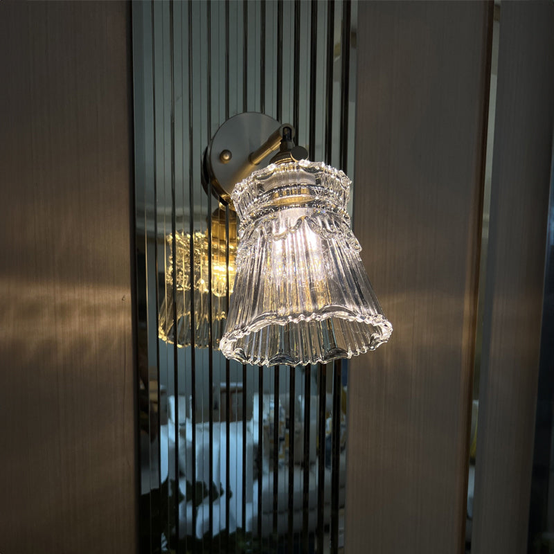 Antique brass glass wall sconce light in elegant setting.